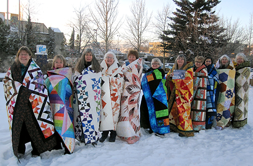 Bear's Paw Quilt staffers  wrapped in their quilts