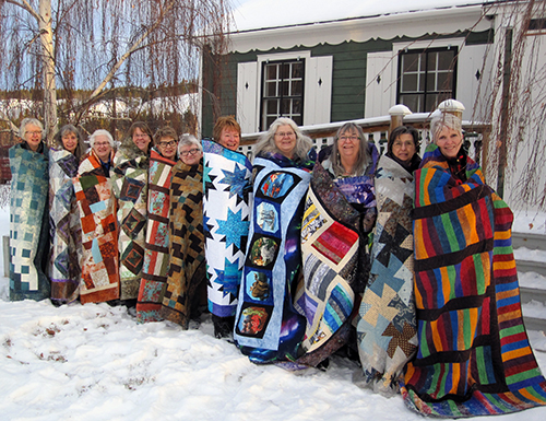 Bear's Paw Quilt staffers  wrapped in their quilts